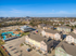 Vibrant aerial view of a modern apartment complex featuring colorful buildings, a winding resort-style pool, and lush landscaping, perfect for a dynamic lifestyle.