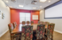 Vibrant meeting room with elegant patterned chairs, a large wooden table, and a modern projector screen, offering a stylish conference setting.