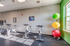 Bright and airy gym room featuring modern spinning bikes and colorful exercise balls, illuminated by natural sunlight.