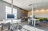 Bright and modern co-working space with sleek computer stations, large windows, and stylish seating area.