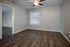 Bright and inviting room with modern hardwood flooring, neutral wall tones, and ample natural light from a large window.