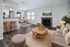 Inviting open-concept living room and kitchen with modern decor, featuring a cozy sofa, elegant dining area, and a charming fireplace, perfect for comfortable living.