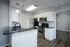 Modern kitchen with sleek stainless steel appliances, stylish black countertops, and elegant white cabinetry, featuring a chic subway tile backsplash.