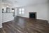 Elegant open-concept living area with sleek hardwood floors, cozy fireplace, and abundant natural light from large windows.