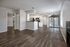 Open-concept living space with sleek wood flooring, modern kitchen, and abundant natural light, ideal for stylish living and entertaining.