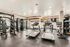Modern fitness center featuring treadmills, strength training equipment, and a variety of exercise machines in a well-lit, spacious room.