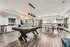 Chic recreational room featuring a sleek pool table, modern table tennis setup, and stylish kitchen area with elegant cabinetry.