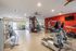 Modern fitness center equipped with state-of-the-art exercise machines, vibrant wall art, and well-lit spacious interiors.
