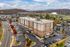 Charming apartment complex surrounded by vibrant autumn foliage, featuring ample parking and scenic views.