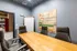 Modern meeting room featuring a wooden table, sleek chairs, and creative wall art.