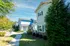Charming suburban homes with scenic pathways, lush greenery, and inviting architecture under a clear blue sky.