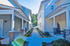 Charming suburban pathway flanked by modern townhouses with inviting porches and lush greenery.