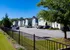 Charming suburban community showcasing neatly arranged modern townhouses, surrounded by lush greenery and ample parking space.