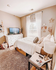 Charming bedroom with cozy decor, featuring a plush bed, elegant drapery, and a stylish dresser with a modern TV setup.