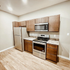 Modern kitchen with stainless steel appliances, sleek wooden cabinets, and elegant countertops.