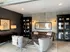 Modern living room featuring a chic leather sofa, elegant bookcases, and stylish armchairs under contemporary lighting.