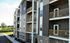 Modern apartment building with stylish balconies, surrounded by lush greenery and a serene environment, offering contemporary living spaces with a touch of nature.