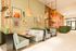 Vibrant lounge area with modern decor, cozy seating, and artistic wall art, perfect for relaxation and work in a trendy environment.