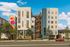 Modern apartment building with eye-catching floral wall art, sleek design, and inviting outdoor staircases.