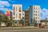 Modern apartment building featuring a colorful floral mural, contemporary design, and inviting street view in a vibrant neighborhood.