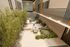Elegant courtyard with lush greenery, string lights, outdoor seating, and modern design elements creating an inviting ambiance.