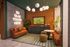 Chic lounge area with modern decor, featuring a warm leather sofa, a stylish round table, glowing welcome sign, and a wall-mounted TV set against lush greenery.