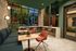 Chic and inviting modern lounge with cozy seating, stylish decor, and large windows showcasing lush greenery.