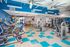 Modern fitness center with state-of-the-art exercise equipment, vibrant blue accents, and ample natural light.