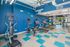 Modern fitness center with bright blue accents, featuring state-of-the-art equipment including ellipticals, treadmills, and exercise bikes, perfect for an energetic workout experience.