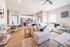 Bright and airy open-plan living space with modern kitchen, stylish dining area, and cozy sectional sofa. Perfect for entertaining and relaxation.