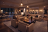 Luxurious open-concept living room with elegant lighting, cozy seating, and a refined dining area in a sophisticated apartment setting.