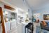 Charming open-concept apartment featuring a modern kitchen, cozy living area, and stylish laundry nook with vibrant decor elements.