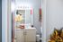 Bright and stylish bathroom with elegant decor, featuring a large mirror, modern vanity with fresh towels, and vibrant plant accents.