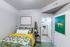 Charming bedroom with stylish decor, vibrant bedding, and modern art, leading to a bright, elegant bathroom.