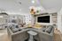 Contemporary lounge area with sleek gray sofas, inviting natural light, and modern decor, perfect for relaxing gatherings.