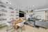 Modern living space featuring a stylish lounge area with sleek gray sofas, artistic wall decor, and a chic round dining table with designer chairs.