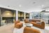Modern and inviting social lounge featuring plush brown seating, chic round tables, and stylish private booths with elegant backlighting.
