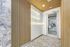 Modern hallway with sleek wooden paneling, inspirational neon quotes, and access to a bright fitness area.