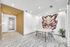 Modern meeting room with stylish decor features a round table, sleek chairs, and an eye-catching abstract artwork on the wall.