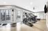 Modern fitness center with state-of-the-art elliptical machines, bright windows overlooking the outdoor patio, and sleek design.