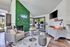 Trendy apartment lobby with a lush green feature wall, cozy seating area, and a modern snack station, creating a welcoming atmosphere.