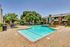Inviting outdoor swimming pool surrounded by lush greenery and modern apartment buildings, offering a perfect space for relaxation and leisure.