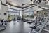 Bright and modern fitness center featuring state-of-the-art exercise equipment, including treadmills, elliptical machines, and weight racks, with large windows and ample natural light.