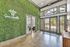 Inviting entrance with lush green feature wall and modern glass doors, perfect for a warm welcome at Arbors of Sam Houston.