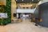 Modern apartment lobby with a vertical garden, sleek reception desk, and stylish seating area.