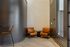 Cozy modern seating area with stylish orange chairs and sleek decor for a welcoming apartment atmosphere.