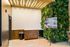 Chic modern lobby corner with a lush vertical garden, sleek wood cabinetry, and stylish lighting, inviting a refreshing ambiance.