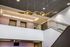 Modern lobby interior with elegant wave-like ceiling feature, stylish railing, and ambient lighting.