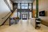 Modern lobby of 865 East with sleek design featuring high ceilings, expansive windows, stylish seating, and a lush green wall accent.