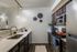 Modern kitchen with sleek stainless steel appliances, elegant lighting, and stylish decor. Featuring dark wood cabinets and a spacious counter for culinary creativity.